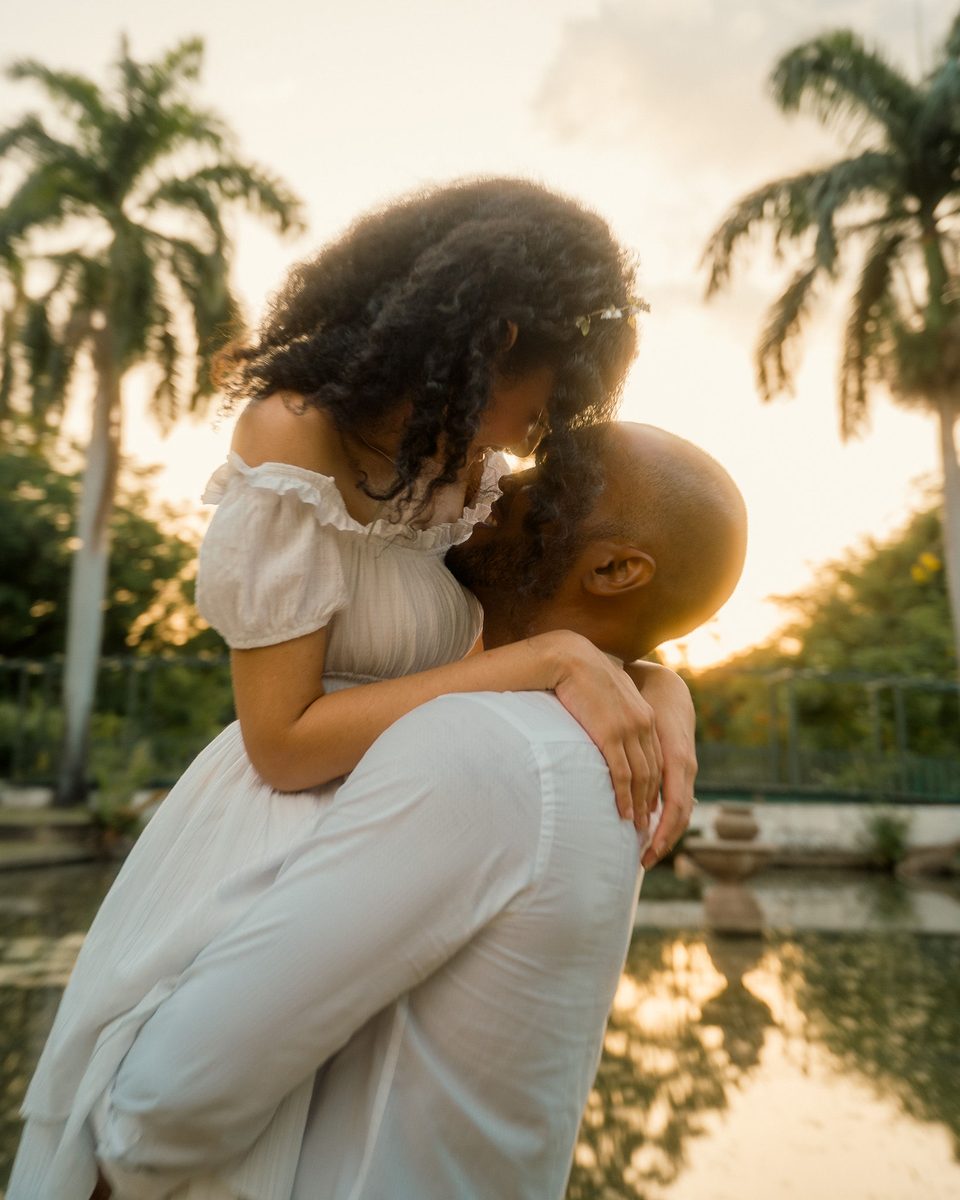 Lifted into a kiss under the palms at sunset.