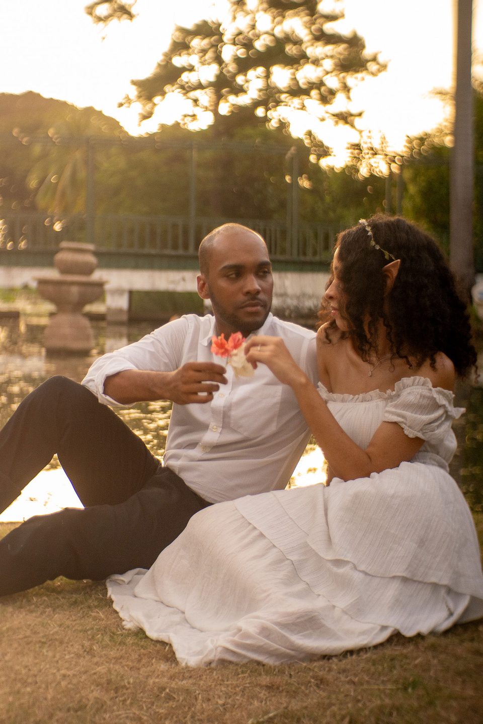 Sitting on the grass by the pond, sharing a hibiscus.